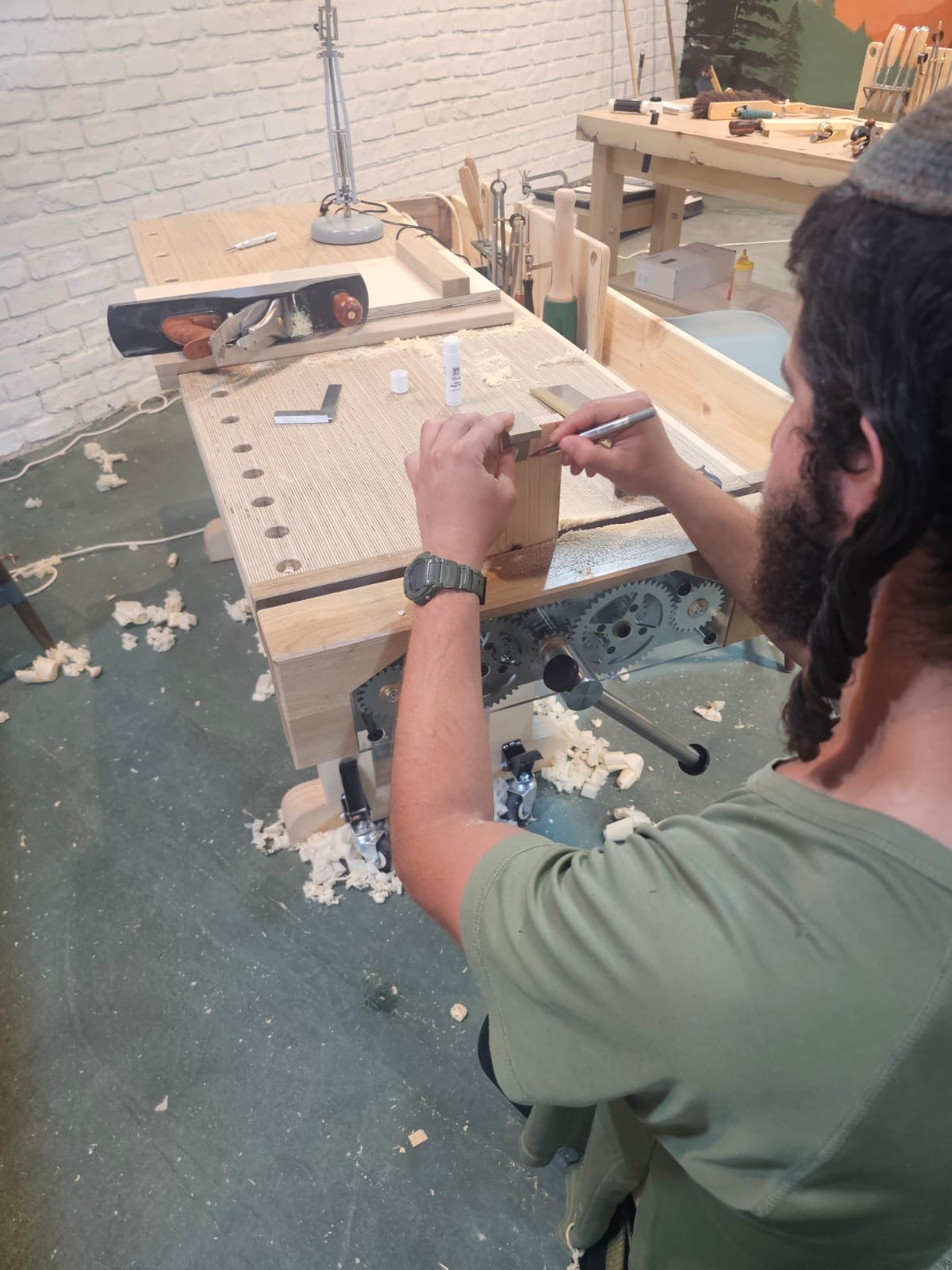Man working at woodworking bench in the indoor workshop